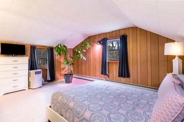 a bedroom with a bed and flat screen tv