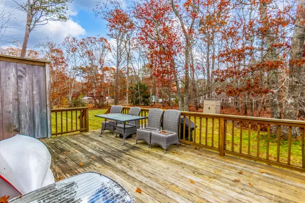a balcony with wooden floor table and chairs
