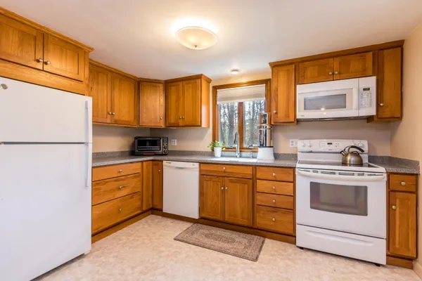 a kitchen with granite countertop white cabinets sink and white appliances