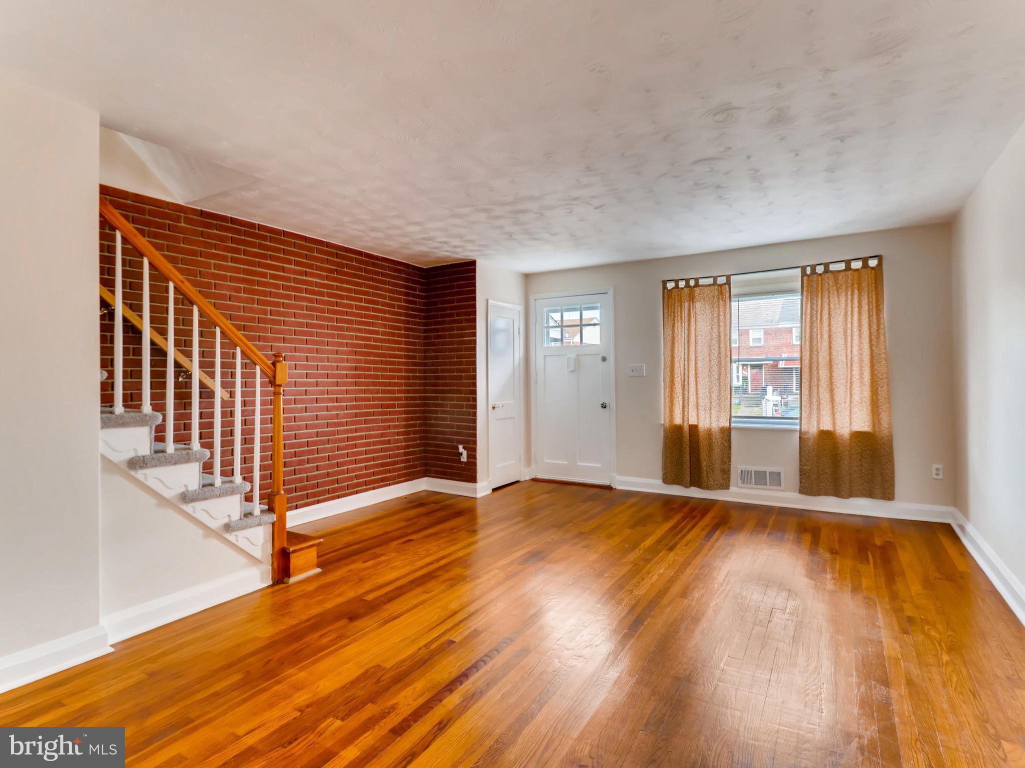 7915 Kavanagh Road Baltimore, MD 21222 - Photo 2 of 12 a view of an empty room with wooden floor and a window