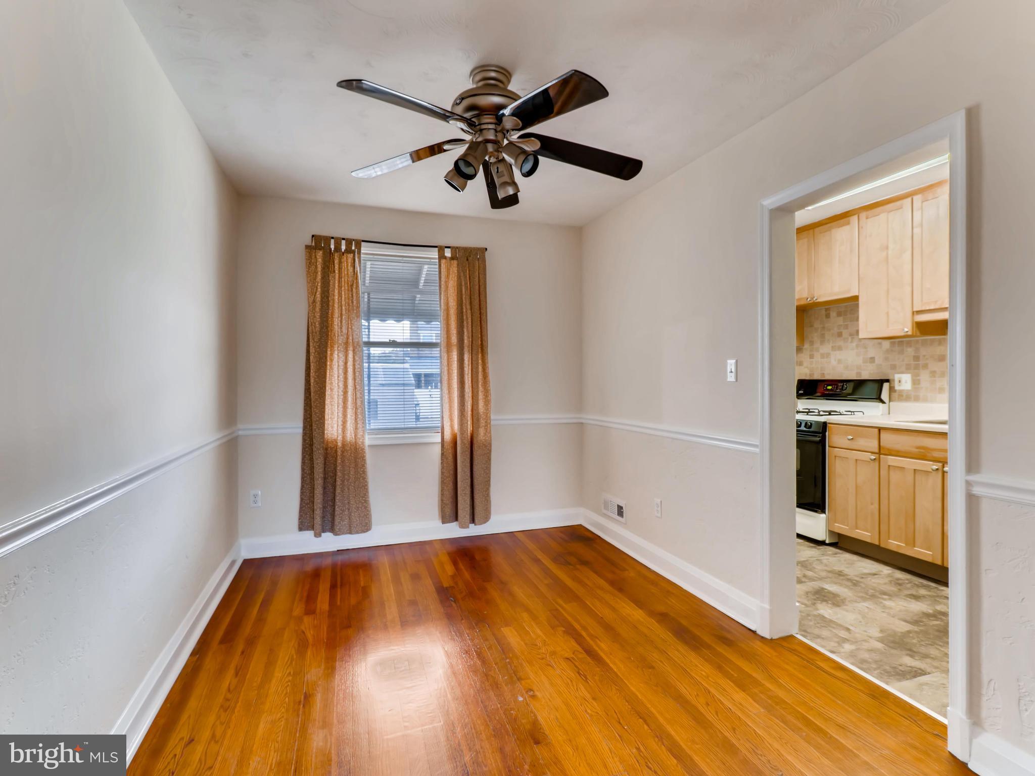 7915 Kavanagh Road Baltimore, MD 21222 - Photo 3 of 12 a view of empty room with wooden floor and a window