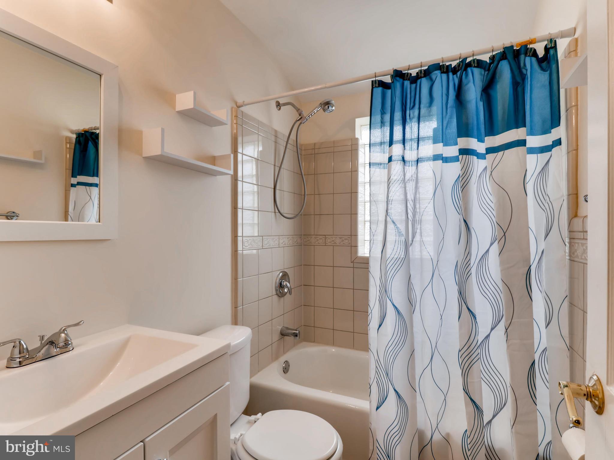7915 Kavanagh Road Baltimore, MD 21222 - Photo 7 of 12 a bathroom with a shower curtain and a sink