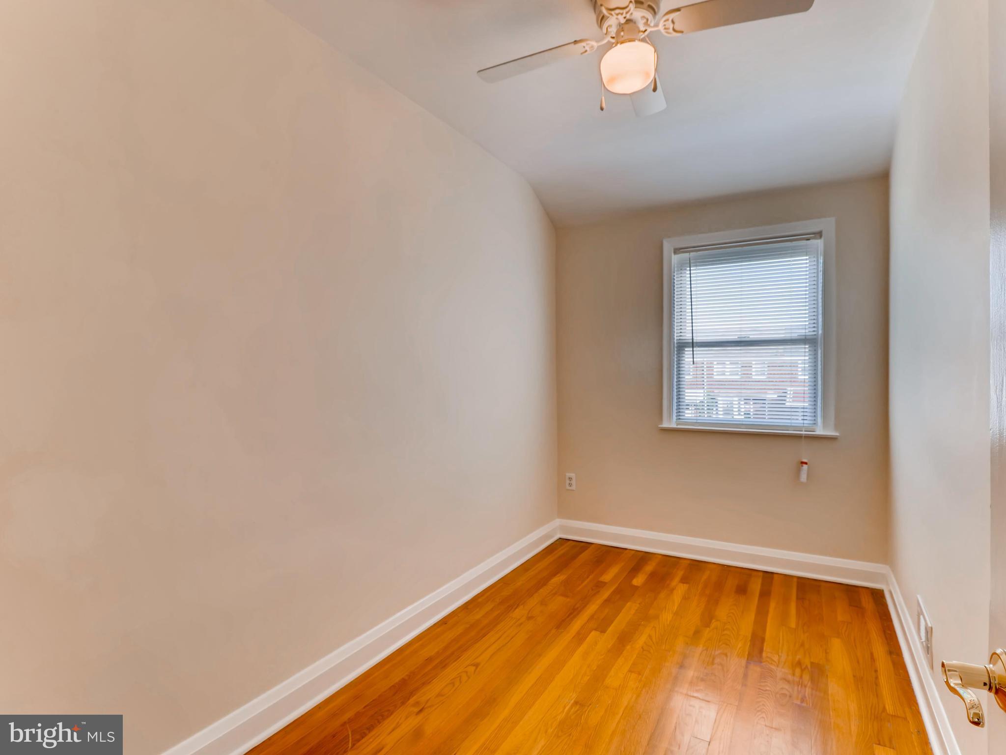 7915 Kavanagh Road Baltimore, MD 21222 - Photo 9 of 12 a view of a room with wooden floor and a ceiling fan