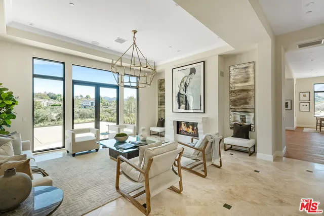 a living room with furniture a fireplace and a large window