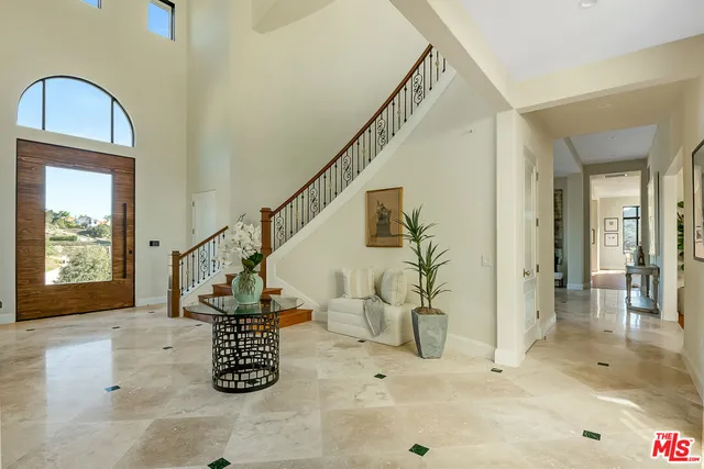 a living room with furniture large window and wooden floor