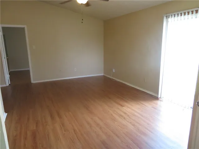 a view of an empty room with wooden floor