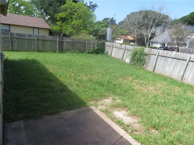 a view of a backyard with a garden and deck