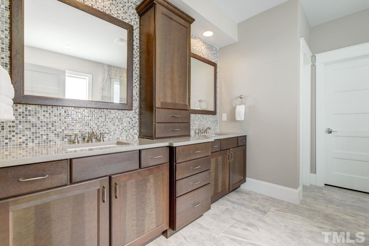 1003 Collins Drive Raleigh, NC 27609 - Photo 13 of 25 Have sweet dreams in the first floor master suite that includes a luxury bath with a large double vanity, Aquatic soaker tub, huge tiled shower, and a walk-in closet with custom organizers.