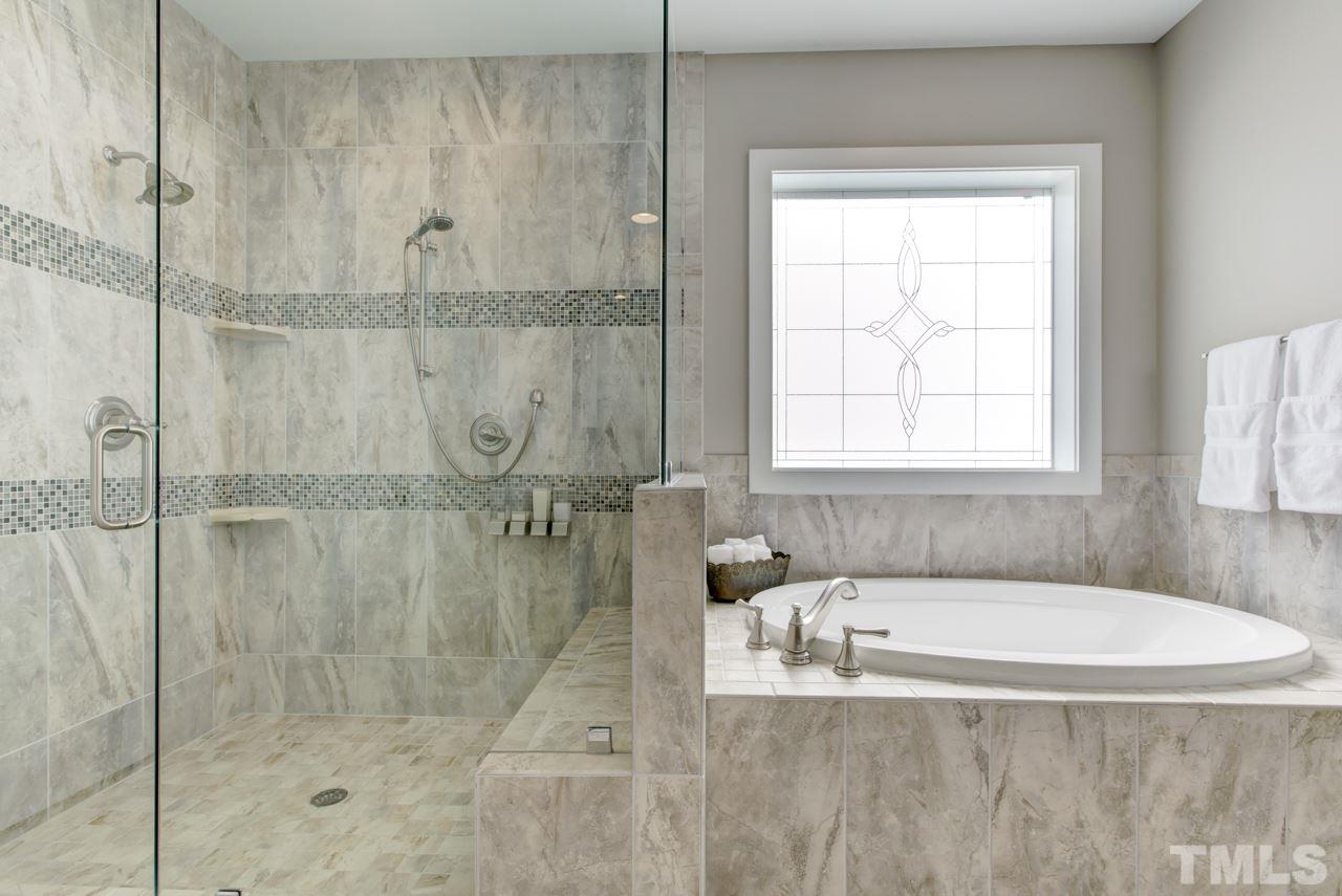 1003 Collins Drive Raleigh, NC 27609 - Photo 14 of 25 Have sweet dreams in the first floor master suite that includes a luxury bath with a large double vanity, Aquatic soaker tub, huge tiled shower, and a walk-in closet with custom organizers.