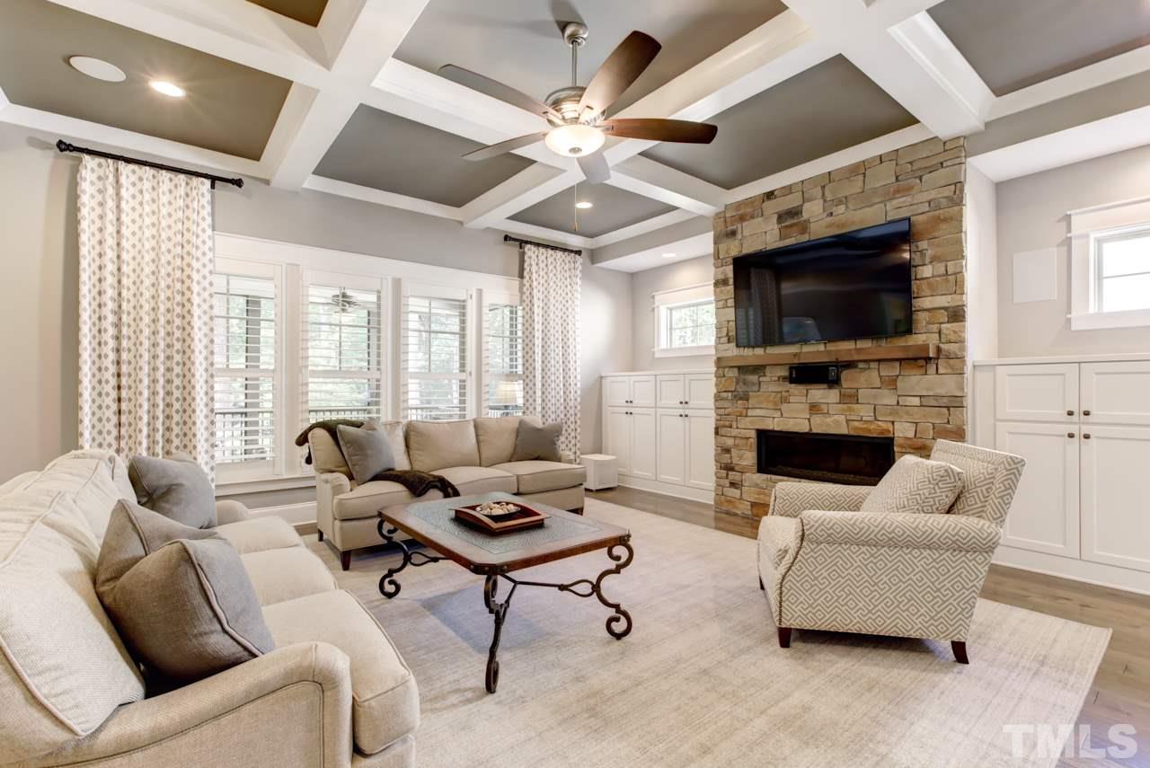1003 Collins Drive Raleigh, NC 27609 - Photo 10 of 25 The family room boasts a coffered ceiling and features a stacked stone fireplace with side bookcases. There is also wall of windows covered with beautiful Plantation shutters.