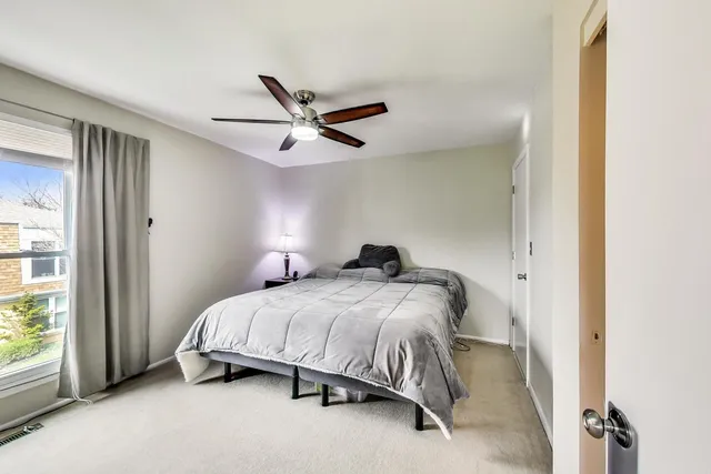 a bedroom with a bed and a ceiling fan