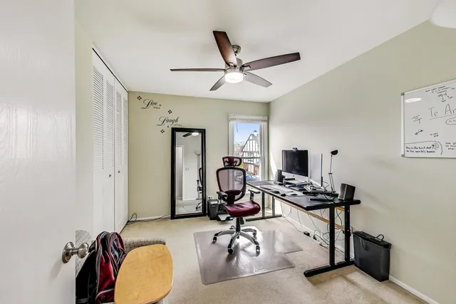 a view of a workspace with furniture and a window