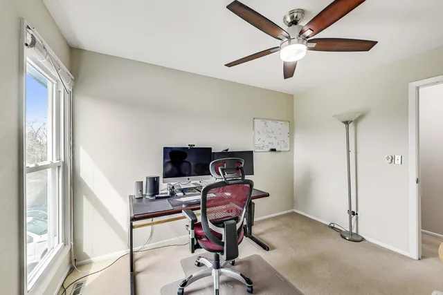 a view of a workspace with furniture and a window