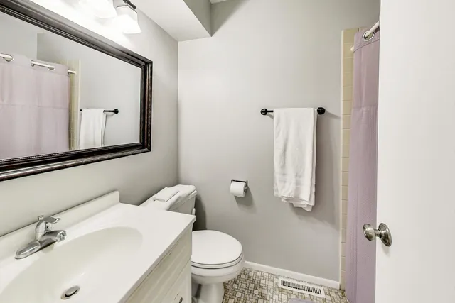 a bathroom with a sink toilet and mirror