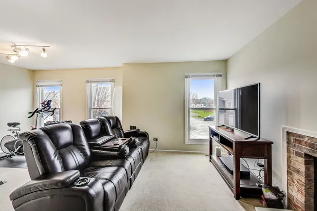 a living room with furniture a flat screen tv and a window