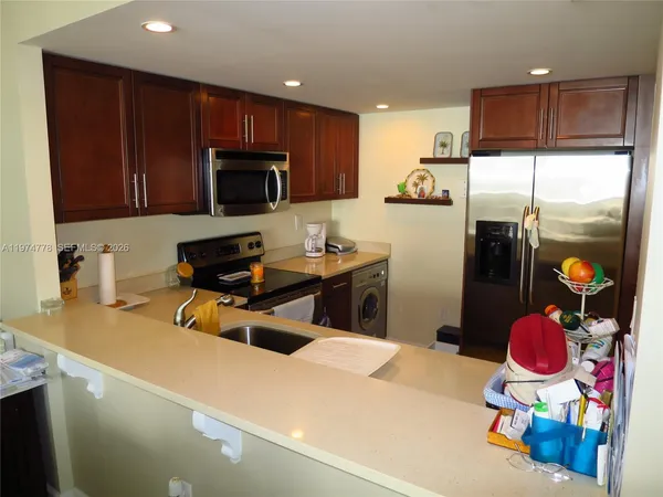 a kitchen with a refrigerator and a stove top oven