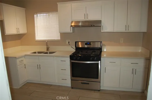 a kitchen with white cabinets and appliances