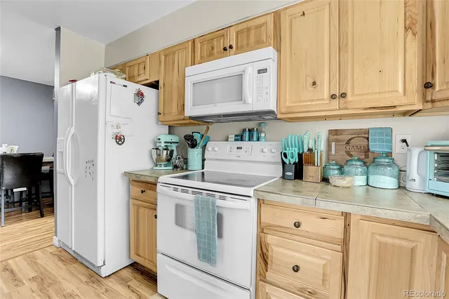 a kitchen with stainless steel appliances granite countertop white cabinets and a refrigerator