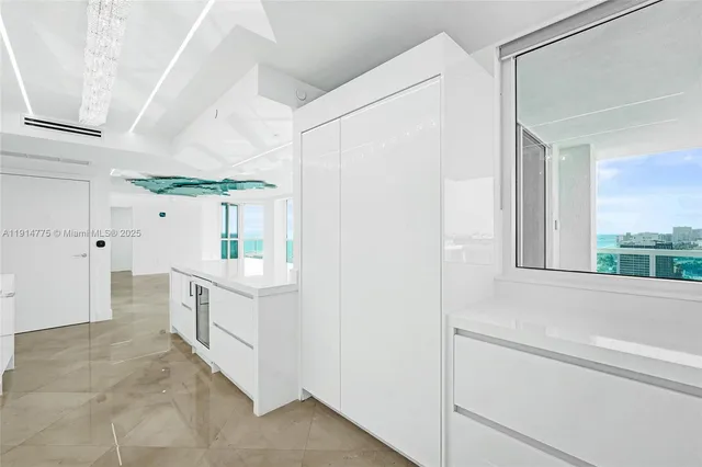 a kitchen with white cabinets and white appliances