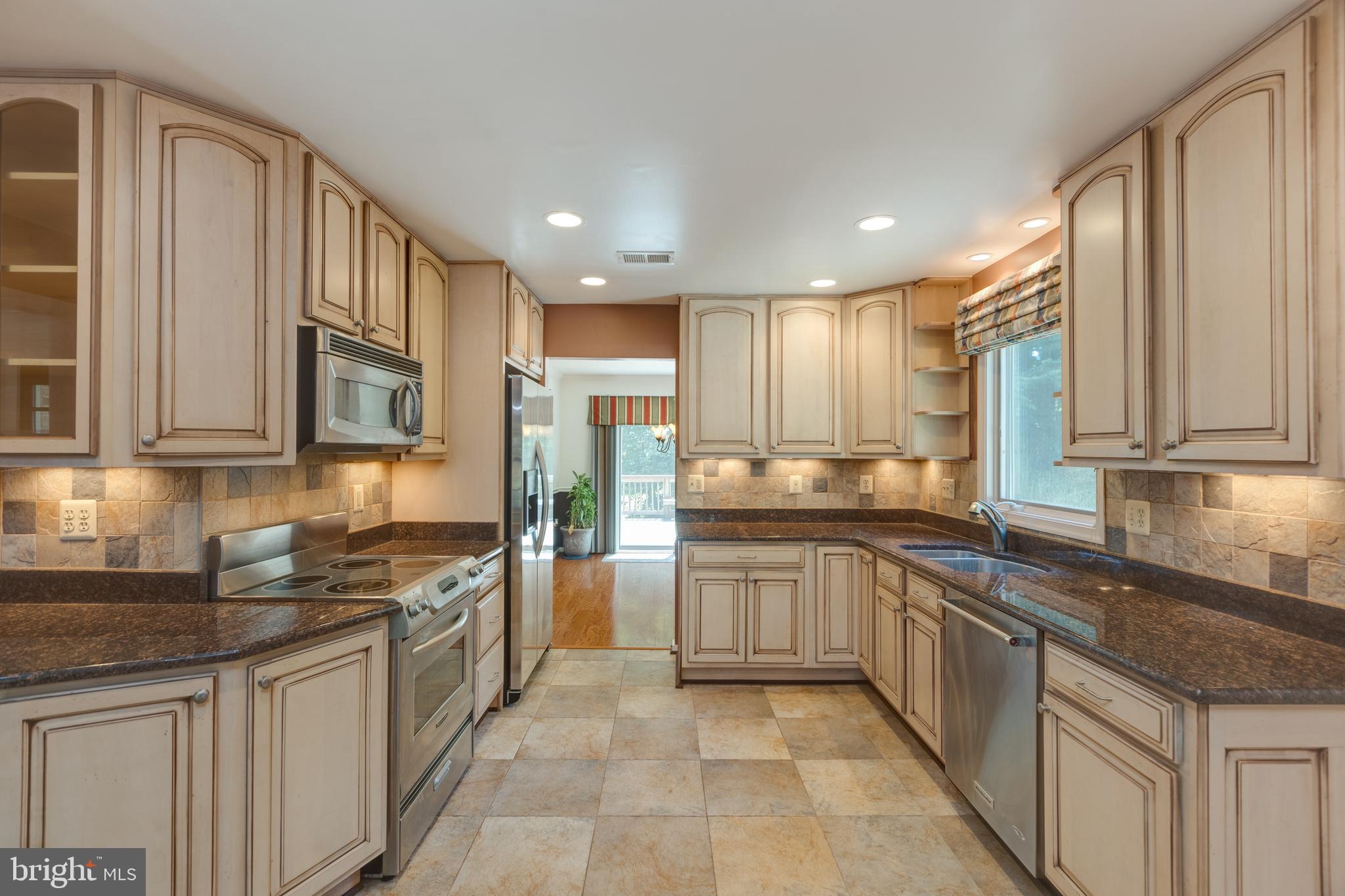 11821 Riders Lane Reston, VA 20191 - Photo 14 of 44 a kitchen with stainless steel appliances granite countertop a stove sink and cabinets