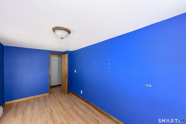 a view of a room with a wooden floor and a ceiling fan