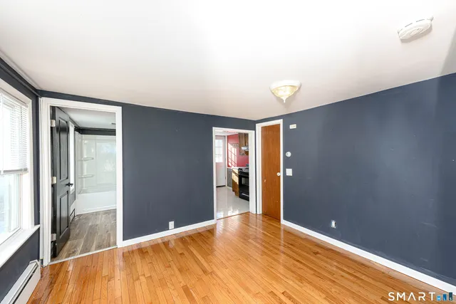 a view of empty room with wooden floor