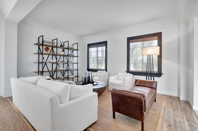 a living room with furniture a large window and a flat screen tv