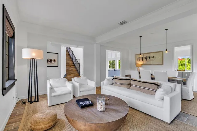 a dining room with furniture a chandelier and wooden floor