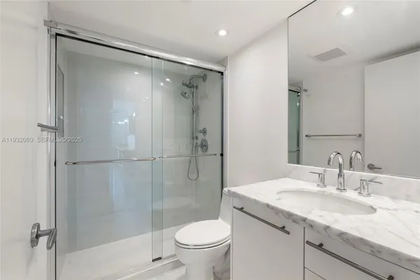 a bathroom with a granite countertop sink toilet and shower