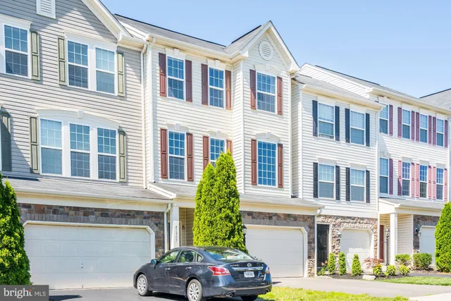 a front view of a building with a garden and plants