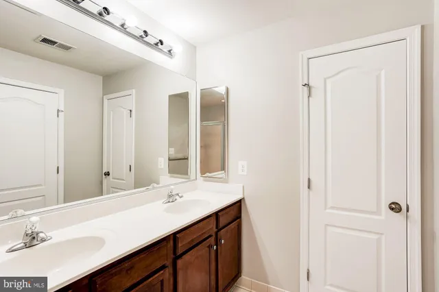 a bathroom with a double vanity sink and a mirror