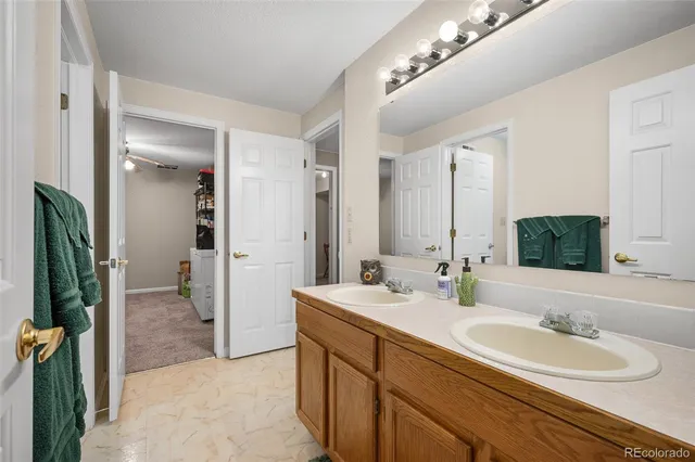 a spacious bathroom with a double vanity sink a mirror and a shower