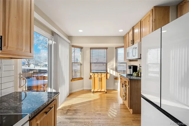 a kitchen with stainless steel appliances granite countertop a refrigerator a stove and a sink