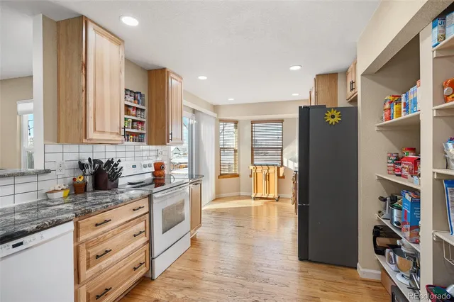 a kitchen with stainless steel appliances granite countertop a refrigerator and a sink
