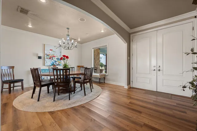 a view of a dining room with furniture a chandelier and wooden floor