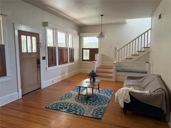 a living room with furniture and wooden floor