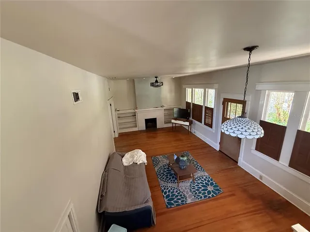 a dining room with furniture a chandelier and wooden floor