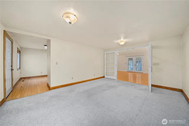 a view of an empty room with wooden floor and a tub