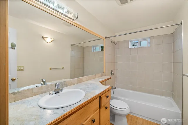 a bathroom with a granite countertop sink toilet and shower