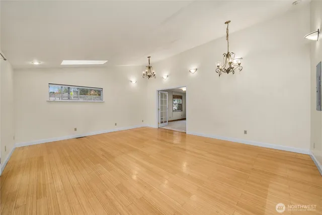 a view of an empty room and chandelier fan