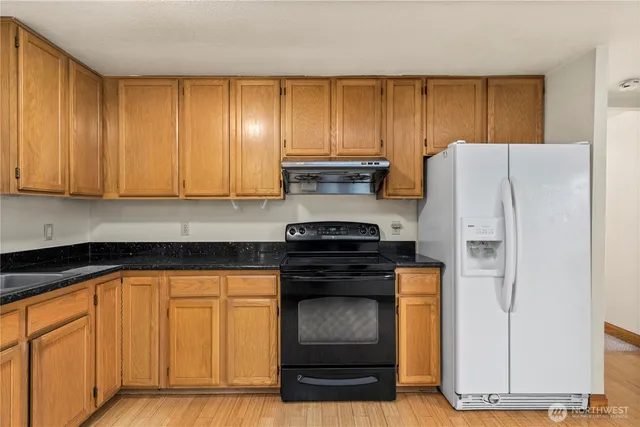 a kitchen with granite countertop cabinets and black appliances
