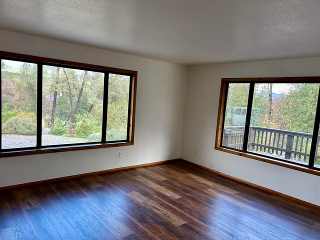 a view of a room with wooden floor chandelier and a window
