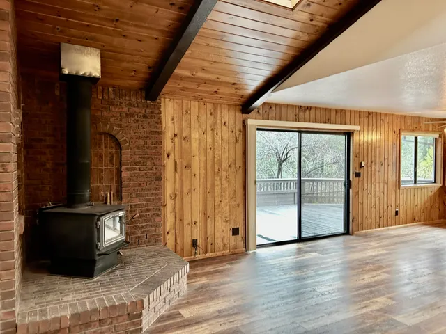 an empty room with wooden floor and a large window