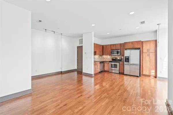 a view of kitchen view wooden floor and electronic appliances