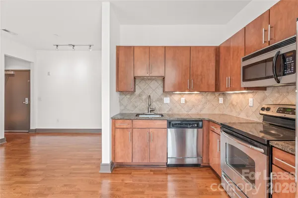 a kitchen with stainless steel appliances granite countertop a stove a sink and a microwave