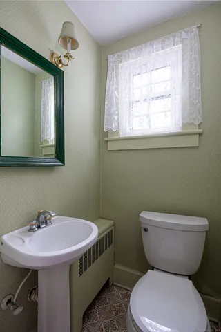 a bathroom with a toilet sink and mirror