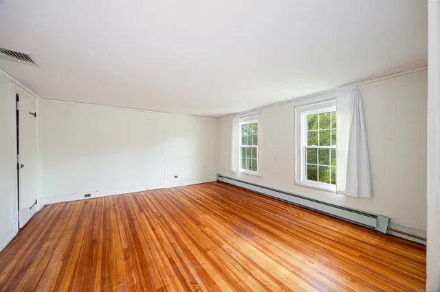 a view of a room with wooden floor and window