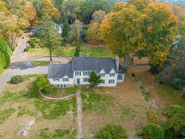 a view of a big house with large tree and plants