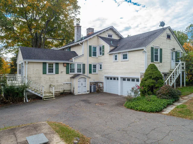 a white house that has a tree in front of it