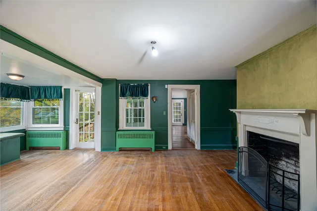 an empty room with a fireplace and windows